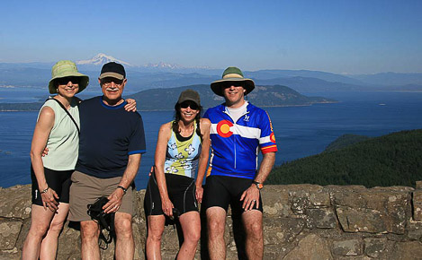 Guests on a biking tour of Orcas Island take a photo in front of Mount Baker